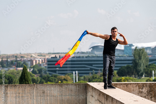 Bipoc male dancer holding colombian flag in rooftop photo