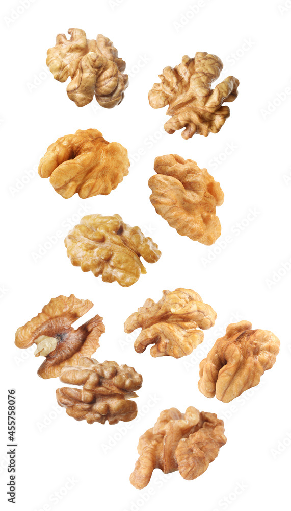 Halves of walnuts falling on white background