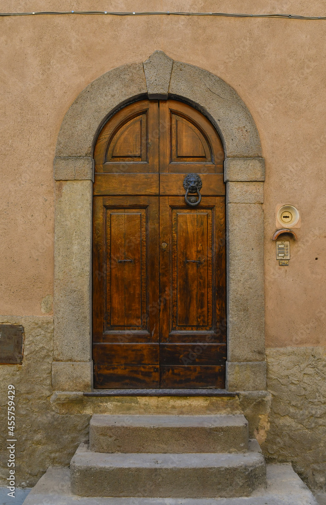 Close-up of the arched door of an old building in the historic centre of Castagneto Carducci, Livorno, Tuscany, Italy