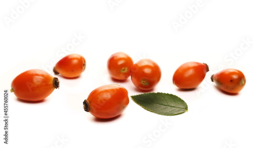 Red dog rose hips and green leaf isolated on white background