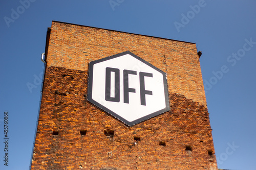 A large inscription OFF on the facade of a brick building on a blue background located at Piotrkowska Street in Lodz