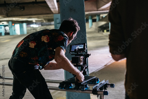 Young cinematographer filming in a parking garage photo