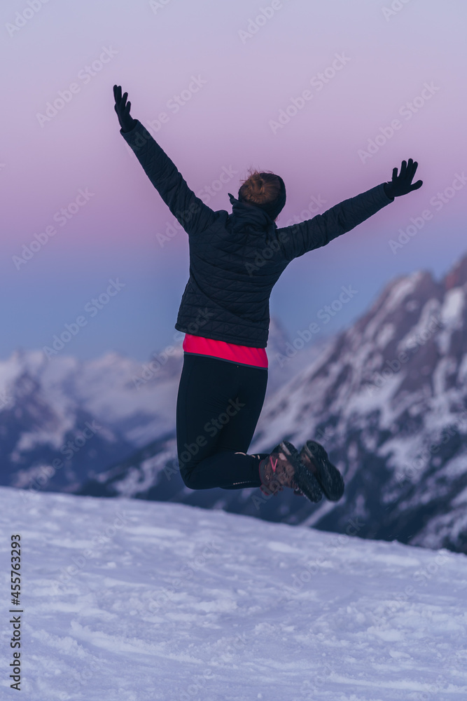 Joyful girl jumping in an alpine winter landscape. Joyful girl jumping in an alpine winter landscape.
