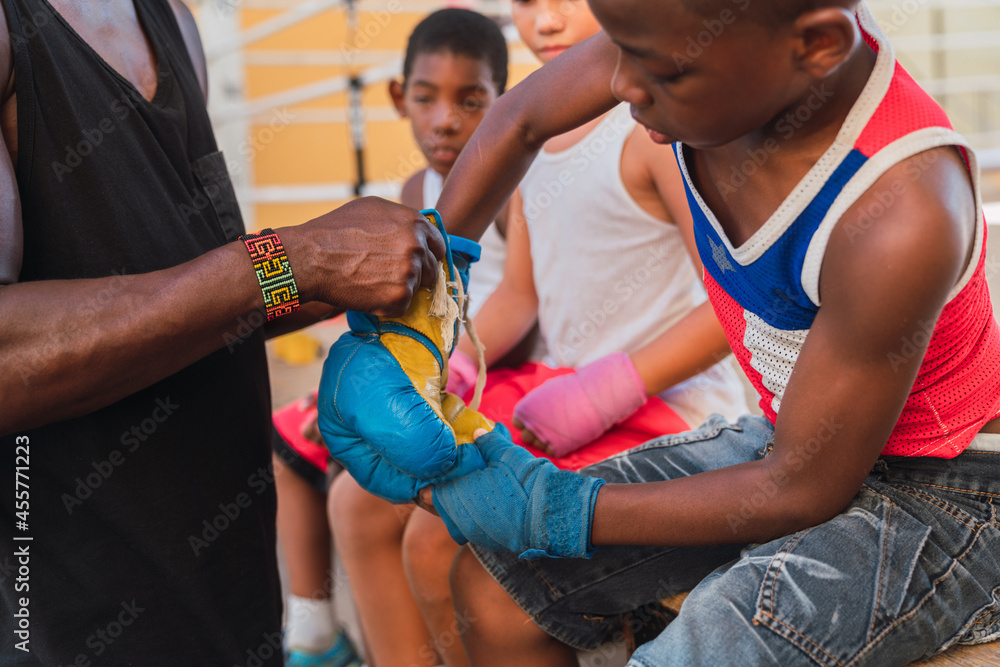 Personal trainer helps fighter put on a glove. Personal trainer helps fighter put on a glove.