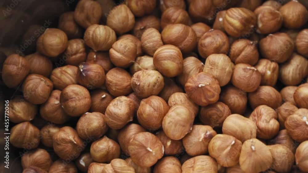 Hazelnuts on a black background. Fresh hazelnut harvest is scattered on a black table. Nuts roll, Hazelnut kernels rotating Hazelnuts on a black background. Fresh hazelnut harvest is scattered on a black table. Nuts roll, Hazelnut kernels rotating