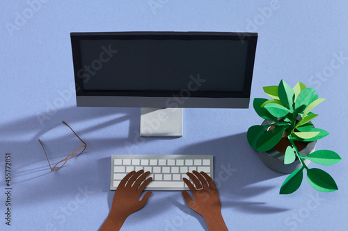 female typing on pc computer with notebook and pot