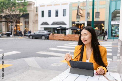 Thoughtful young businesswoman with credit card sitting at cafe table photo