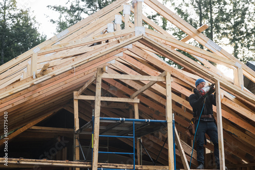 Man working with nail gun doing construction in winter photo