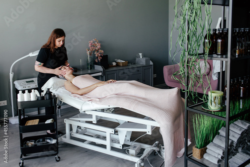 Beautician massaging face of woman photo