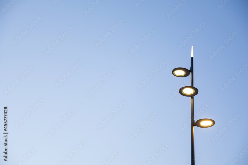 Modern street lamp in a minimalist style view on the blue sky as a background in sunset Modern street lamp in a minimalist style view on the blue sky as a background in sunset