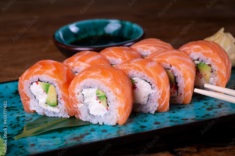 Sushi set with red fish on the table on blue dishes - obrazy, fototapety, plakaty 