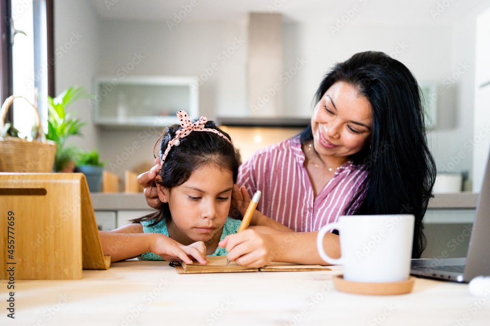 © Eloisa Ramos/Stocksy - Latin mother helping her daughter do homework