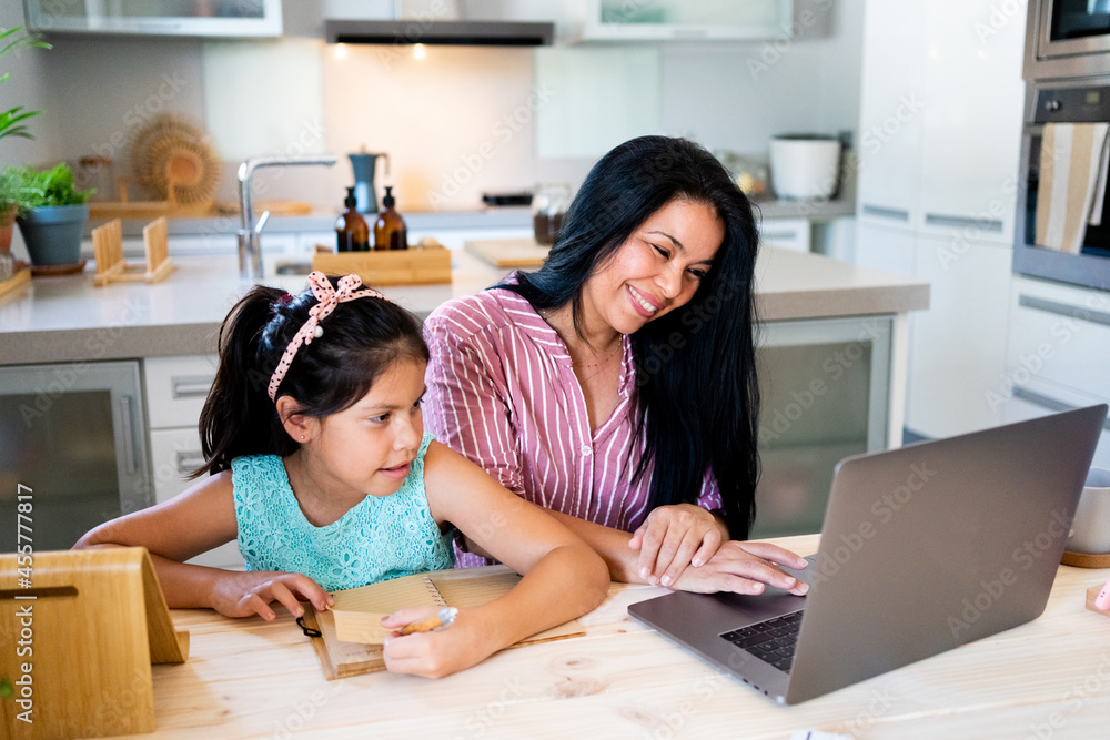 Mother and daughter doing homework together at kitchen Mother and daughter doing homework together at kitchen