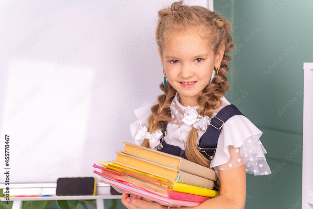 Back to school! Happy cute industrious child is sitting at a desk indoors. Kid is learning in class. Back to school! Happy cute industrious child is sitting at a desk indoors. Kid is learning in class.