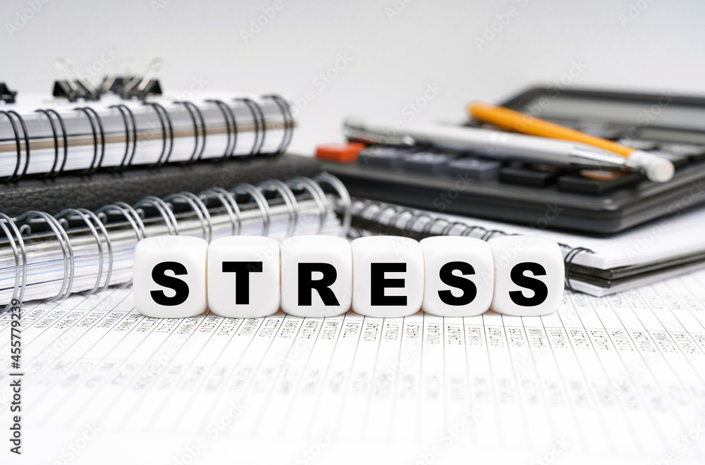 On the table, among office objects, cubes with the inscription - STRESS