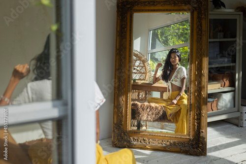Indian Chinese bohemian woman looking at the mirror photo