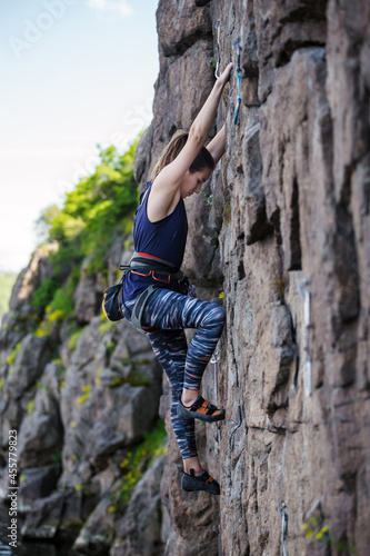 A girl climbs a rock