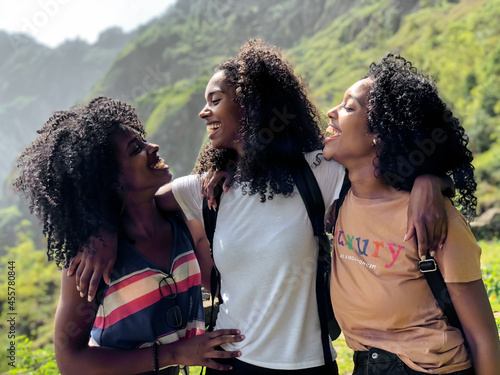 black ethnic afro sisters looking at camera while hiking photo