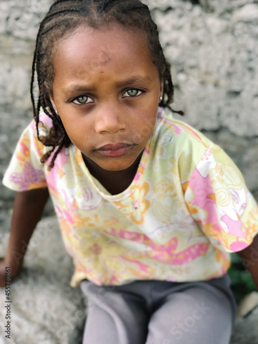 Cute little african girl with green eyes looking at camera
