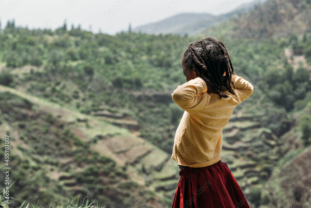 Cute girl looking away while standing outdoors in the mountains Cute girl looking away while standing outdoors in the mountains