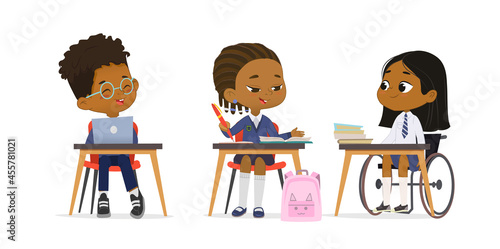 Cute primary pupils studying at diverse inclusion school wearing uniform at lesson vector flat illustration. Dark skin girl in wheelchair talking with multiracial classmates at table isolated on white