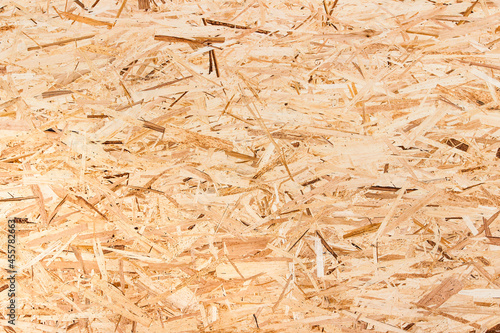 Pressed wooden shavings panel background. OSB boards are made of brown wood chips sanded into a wooden background. Wood Texture Background