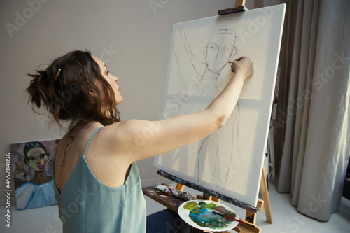 the artist painting a portrait on canvas with charcoal photo