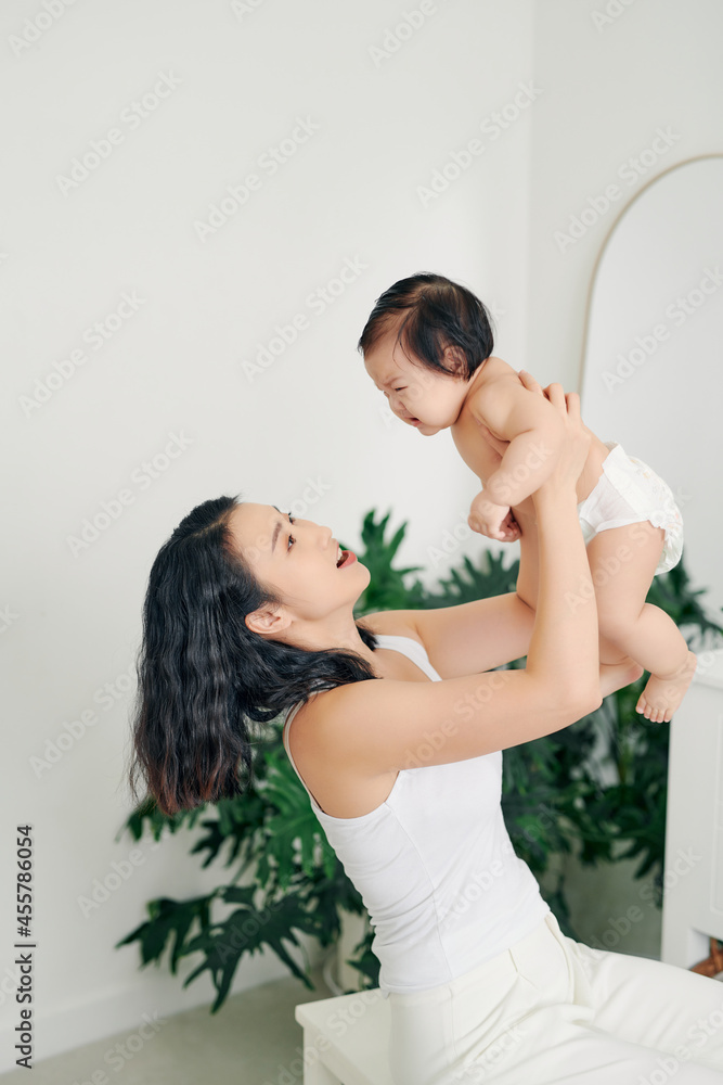 Portrait of Asian mother lifting and playing with baby Portrait of Asian mother lifting and playing with baby