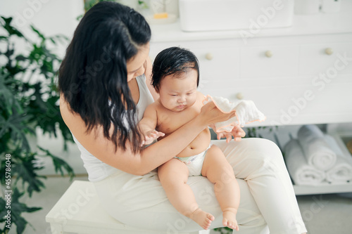 young mom wiping the baby skin with wet wipes photo