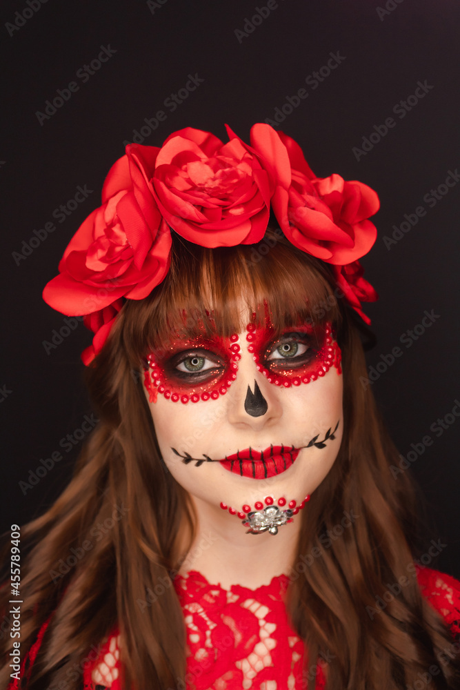 Portrait detail of the face of an adorable girl with Day of the Dead makeup on black background. Portrait detail of the face of an adorable girl with Day of the Dead makeup on black background.