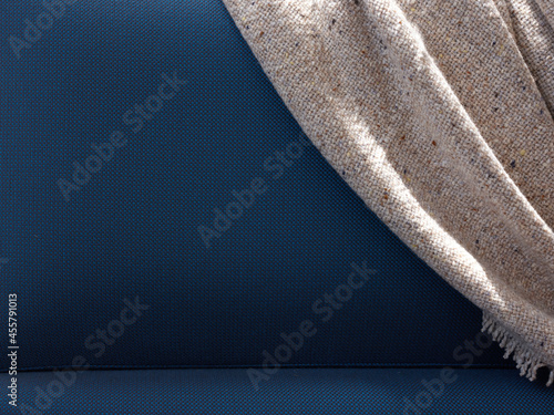Soft gray blanket on blue couch back