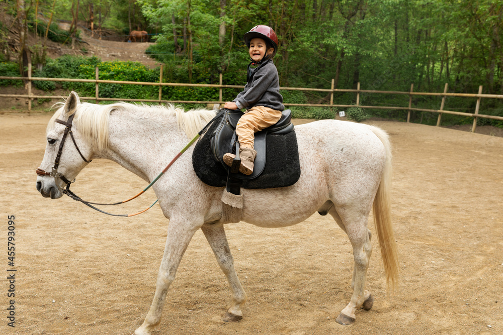 Child having fun riding a horse in nature Child having fun riding a horse in nature