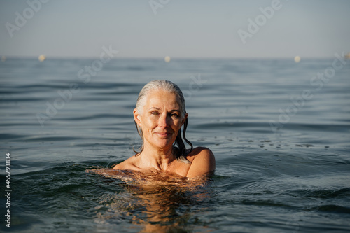 Wallpaper Mural Active mature woman enjoying the beach in the morning Torontodigital.ca