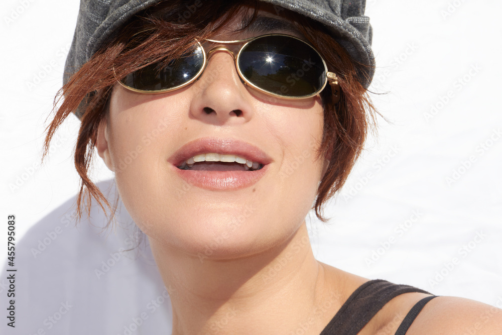 Naklejka premium Attractive woman wearing trendy sunglasses with sunburst on lens