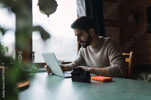 Serious bearded man using laptop photo