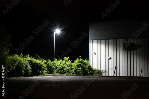 A minimal design of a street light next to a modern factory  photo