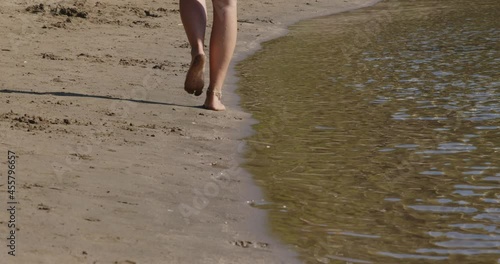 A girl is walking barefoot on the sand beach in Saplunara, Mljet island, Croatia photo