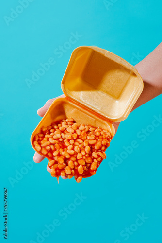 man slopping baked beans from a foam box