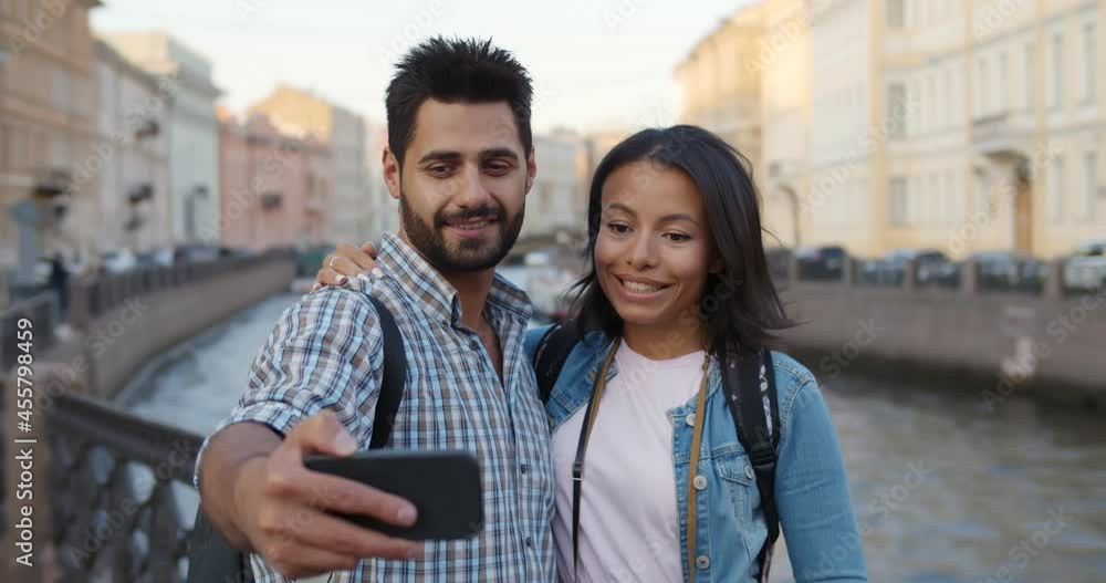 Happy multiethnic couple of tourists taking selfie in old city Happy multiethnic couple of tourists taking selfie in old city