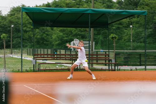 Young tennis player on the outdoor court.  photo