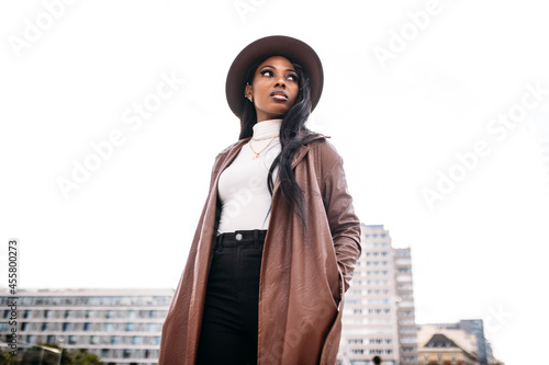 Serious black woman in leather coat and hat photo