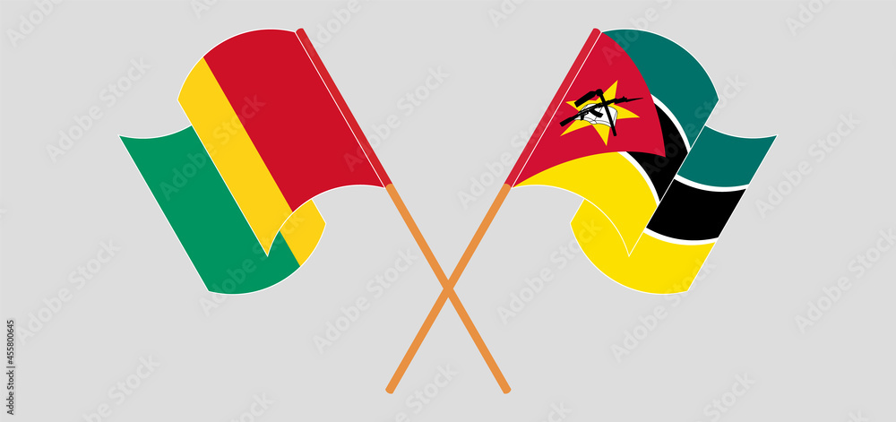 Crossed and waving flags of Guinea and Mozambique Crossed and waving flags of Guinea and Mozambique