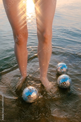 feet in the sea with mirror balls photo