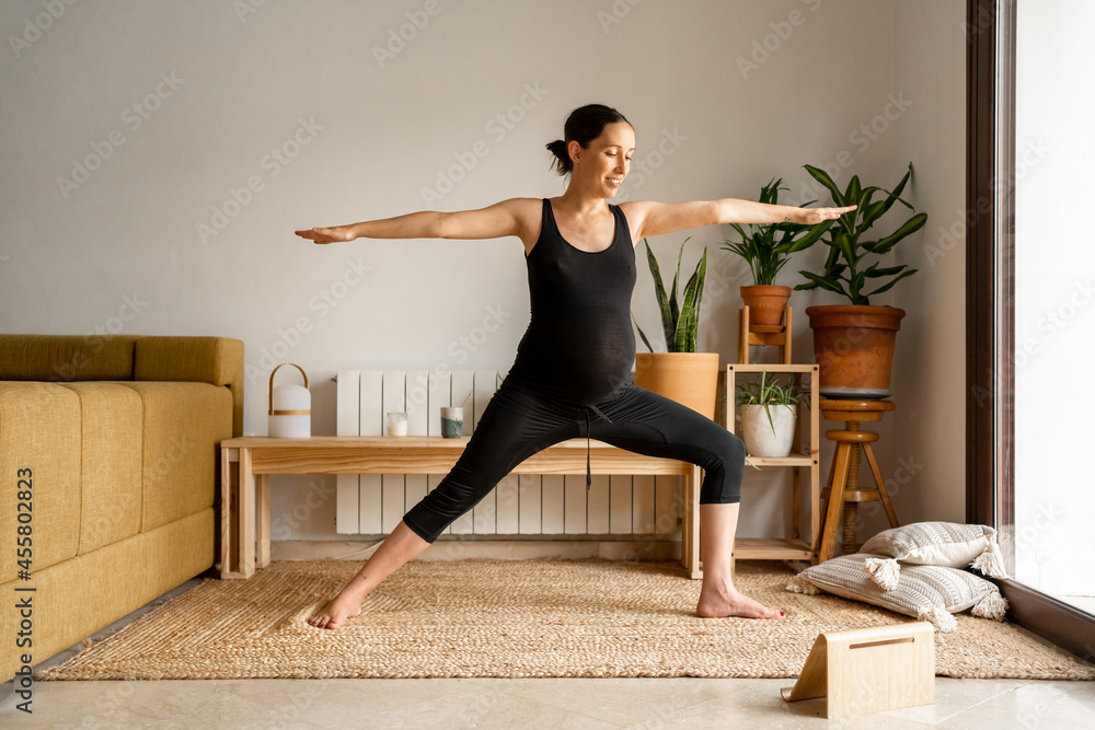 Gravid woman practicing yoga fitness at home Gravid woman practicing yoga fitness at home