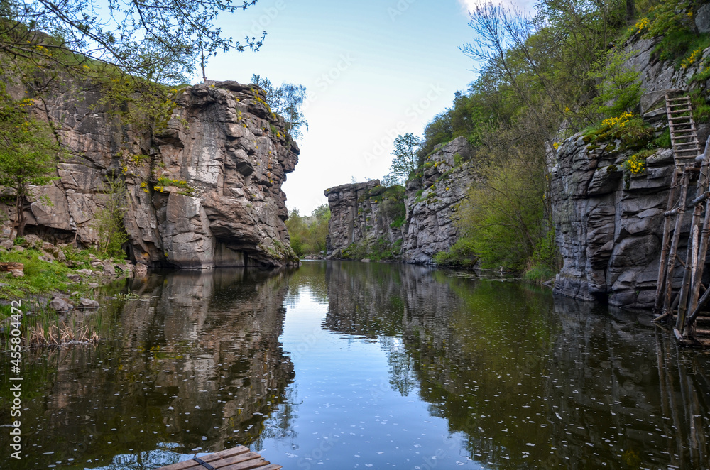 Nature Landscape view of rocky canyon and a calm river with water reflection at the Buky village, Ukraine