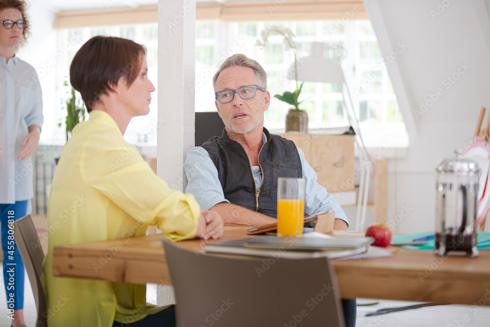 Fototapeta premium Man and woman sitting in office,smiling and talking