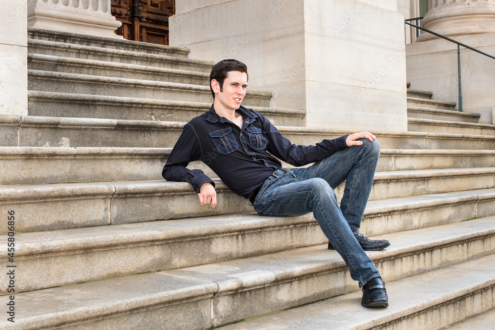 A young handsome guy is sitting on steps and relaxing.. A young handsome guy is sitting on steps and relaxing..