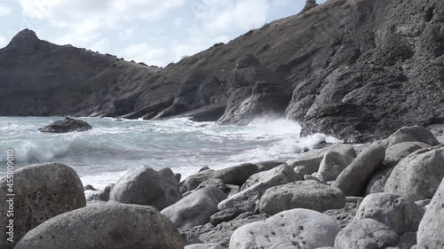 Water splashing. Pirate Bay Novy Svet Places. Crimea. Sea water beats against rocks. Sea waves of blue-gray water beat against the coastal rocks. An infinite number of splashes, drops of water and