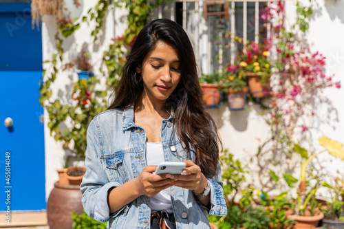 Portrait of happy confident woman with phone outdoors photo