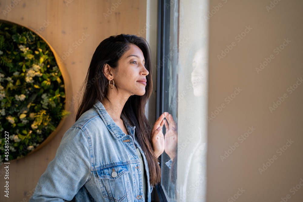 © Alba Vitta/Stocksy - Pensive Young woman looking through window © Alba Vitta/Stocksy - Pensive Young woman looking through window